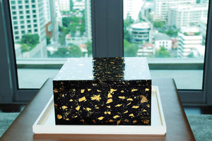 die Lackbox Box Gold teht vor einem Fenster
