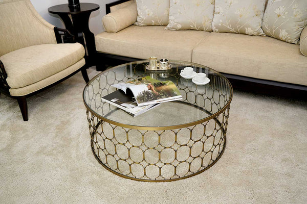 Couchtisch in Metalldesign mit Geschirr vor Sessel und Sofa