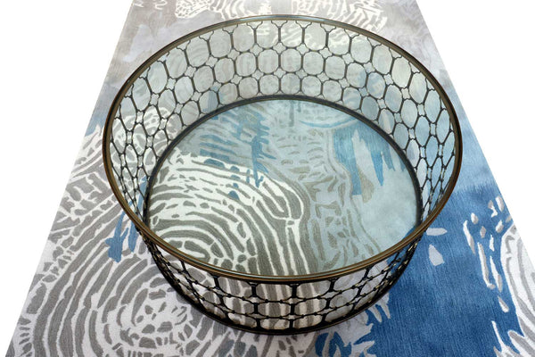 Couchtisch mit Metalldesign und Glasplatte auf Teppich