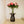 skulpturartiger Beistelltisch mit Blumen vor einer Treppe