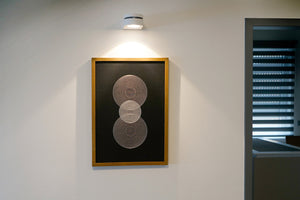 das moderne Stickbild Sphere an der Wand mit Beleuchtung
