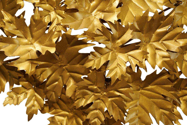 die Blätter der metallenen Wanddekoration in hellgold